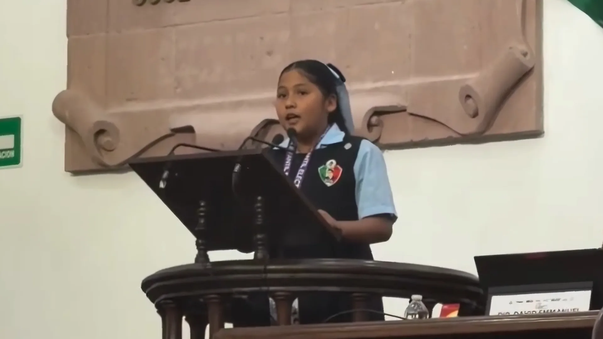 Muestra a la estudiante de primaria, exponiendo su tema frente al Congreso del Estado de Coahuila